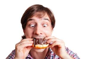 Funny man looks at the chocolate doughnut bulging eyes photo