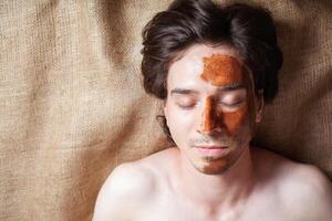 chocolate mascarilla, un hombre en un belleza salón con chocolate en su cara foto