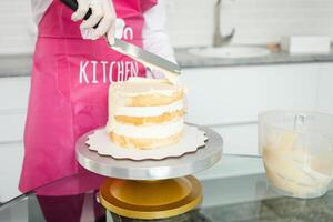 enguantado Pastelería cocinero decora pastel con blanco chocolate. hermosa hecho en casa pastel foto