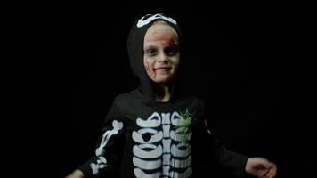 Halloween angry girl with blood makeup on face. Kid dressed as scary skeleton, dancing, making faces video