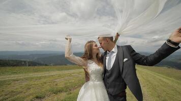 Groom with bride having fun on a mountain hills. Wedding couple. Happy family video