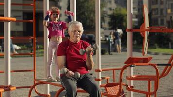 neta e avô fazendo ginástica exercícios com halteres. Senior homem com criança criança menina video