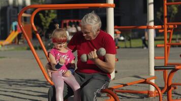 neta e avô fazendo ginástica exercícios com halteres. Senior homem com criança criança menina video