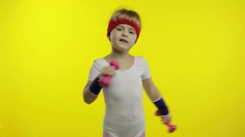 caucasien fille dans tenue de sport fabrication des exercices avec haltères. faire des exercices pour enfants. athlétique enfant video