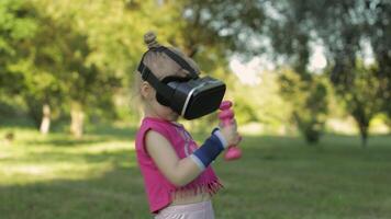 atletisch kind meisje in vr koptelefoon helm maken geschiktheid training opdrachten met halters in park video