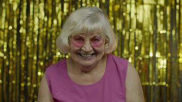 positief senior oud vrouw in zonnebril genieten van, lachend, tevreden met leven, mooi zo stemming, succes video