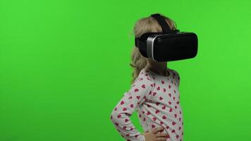 Child girl using VR helmet to play simulation game app. Watch virtual reality 3d video. Chroma key video