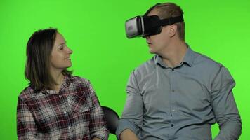 Man and woman using VR headset helmet to play game. Watching virtual reality 3D video. Chroma key video