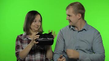 Man and woman using VR headset helmet to play game. Watching virtual reality 3D video. Chroma key video