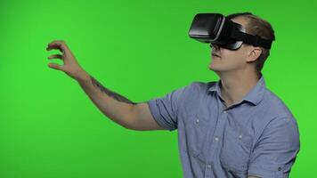 Man using VR app helmet to play simulation game, drawing. Guy watching virtual reality 3d video