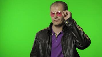 hermoso balancín hombre en rosado Gafas de sol señalando dedo a tú, mirando a cámara, haciendo elección video