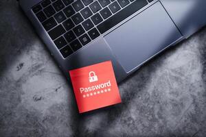 Red post it on laptop with password written on it to protect information on digital devices. Cybersecurity and privacy protect data. Pin code. Cyber hacker threat. photo