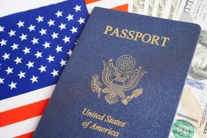 US passport with dollar money on USA flag, American citizen in United States of America. photo