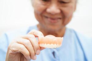 Doctor holding teeth denture in hand for dentist studying about dentistry. photo