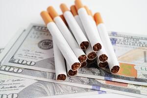 Cigarette on US dollar banknotes, cost, trading, marketing and production, No smoking concept. photo