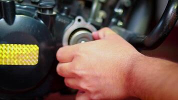 automóvel mecânico homem remove óleo filtro, retirar óleo filtro em motocicleta para manutenção ou reparar video