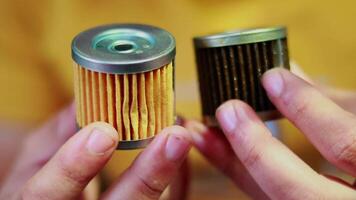 Händchen halten Verwendet ein Motor Öl Filter und ein Neu Motor Öl Filter, ein verwenden und ein Neu Öl oder Treibstoff Filter von das Motorrad ist im das Hände von ein Motorrad Mechaniker, video