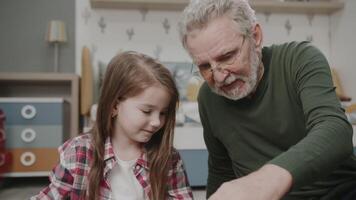 The granddaughter plays with her grandfather in toys in the nursery. They laugh and joke at each other. Portrait of a sweet and happy family. Vivid emotions . The story of one family. video