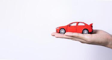 Hand holding a toy car isolated on gradient background. After some edits. photo