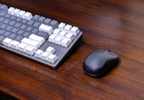 A modern mechanical keyboard and mouse on a wooden table. After some edits. photo