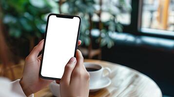 AI generated Woman Hand Holding Smart phone Mockup, Coffee Shop Scene, White Blank Screen photo