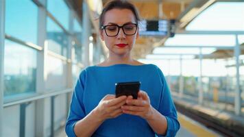 mujer caminando a lo largo el público transporte detener y utilizando teléfono inteligente video