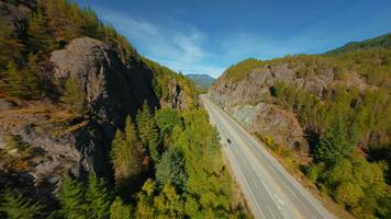 Maneuverable flight by FPV drone over mountain landscape and road video