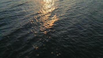 Aerial view of the blue surface of the sea or ocean at sunset video