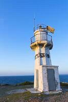 Lighthouse on background of blue clear sky photo