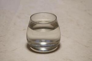 A glass filled with water stands on the countertop photo