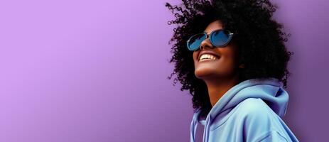 AI generated Studio shot of young dark skinned woman wearing sunglasses and smiling while isolated over purple background. Header with empty space for text, logo or product. photo