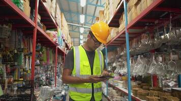 Warehouse full of shelves with goods Male clerk holding a stock checking tablet while scanning parcels logistics distribution center. video