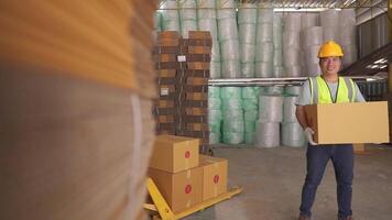 Asia worker holding cardboard box smiling happily and looking at camera while doing shipping and deliveries.Cardboard Boxes, Workers Scan and Sort Packages.Product Distribution Logistics Center. video