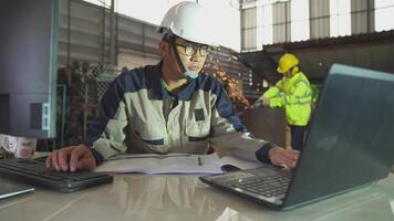 Asia joven industrial ingeniero utilizar tecnología trabajos en el personal computadora. instalaciones operador control S taller producción línea. industria moderno fábrica concepto. video