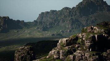 A mountain range with rocks and grass in the foreground video