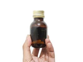 fingers holding or grasping a glass bottle isolated on a white background photo