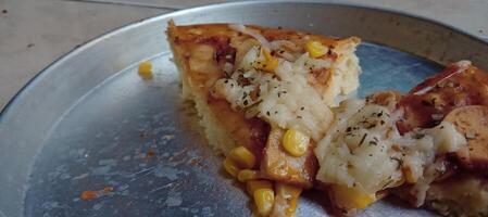 Corn pizza slice with cheese and sausage photo