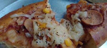 Corn pizza slice with cheese and sausage photo