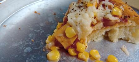 Corn pizza slice with cheese and sausage photo