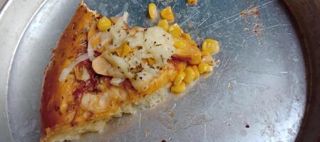 Corn pizza slice with cheese and sausage photo