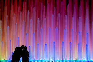 Silhouette of a couple in front of a colourful fountain at the Park of the Reserve Circuito Magico del Agua in Lima, Peru photo