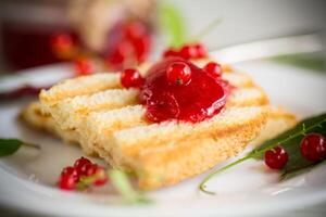 fried bread croutons for breakfast with redcurrant jam in a plate with berries photo