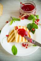 fried bread croutons for breakfast with redcurrant jam in a plate with berries photo