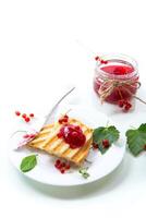 fried bread croutons for breakfast with redcurrant jam in a plate with berries photo