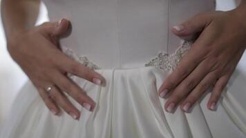 Bride in wedding dress. Hand touches dress. Pretty and well-groomed woman video