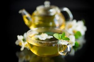 Composition with cup of jasmine tea and flowers photo