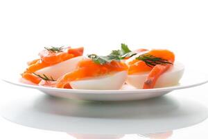 halves of boiled eggs with pieces of salted salmon on white background photo