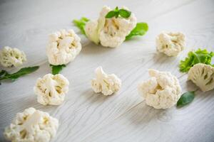 inflorescences of small cauliflower on a light wooden table photo