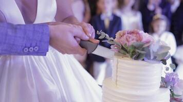 novia y un novio es corte su Boda pastel. manos cortar de un rebanada de un pastel video