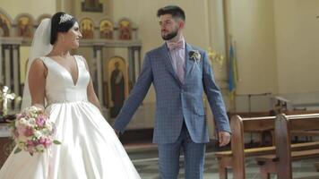 Elegant bride and groom walking together in an old church. Wedding couple video